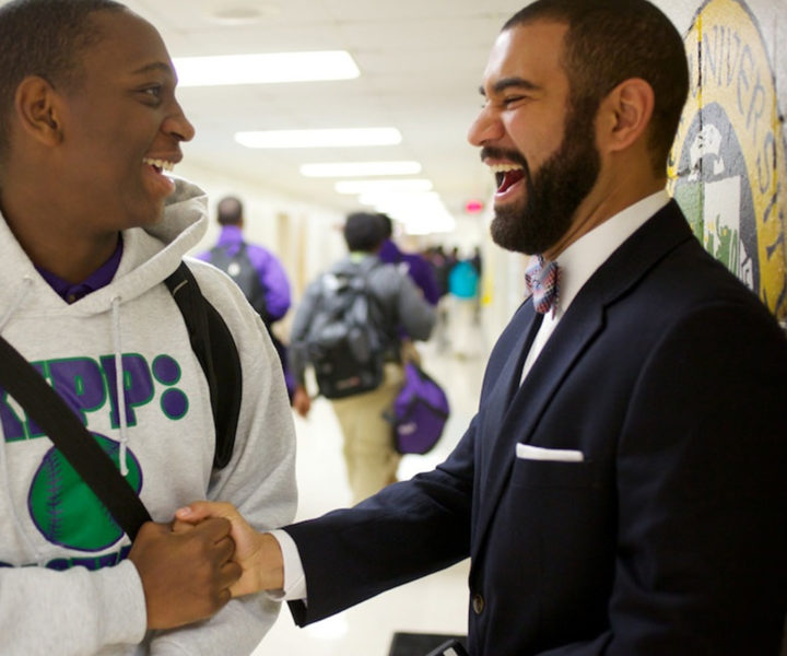 Principal and student shake hands and smile in greeting